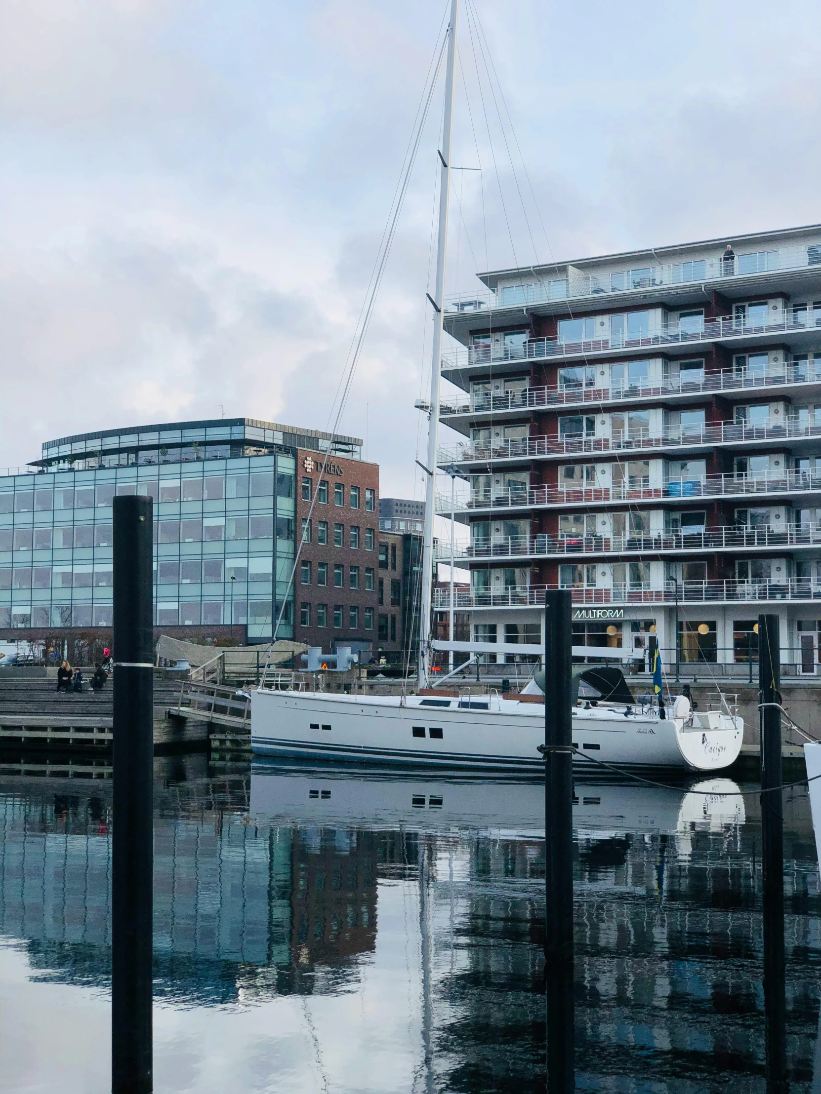 a boat that is sitting in the water, inspired by Wilhelm Marstrand, happening, modern buildings, at the waterside, moored, thumbnail