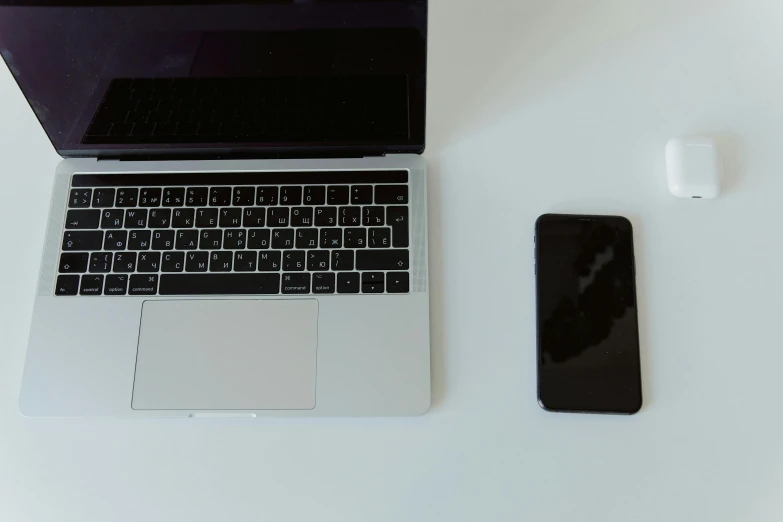 a laptop computer sitting on top of a white table, unsplash, iphone 13, repairing the other one, white and black, plain background