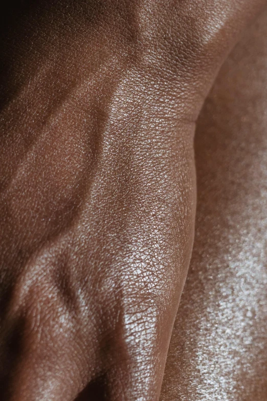 a close up of a person's hand with a ring on it, an album cover, by Nina Hamnett, hyperrealism, brown skin like soil, huge glistening muscles, closeup 4k, leather