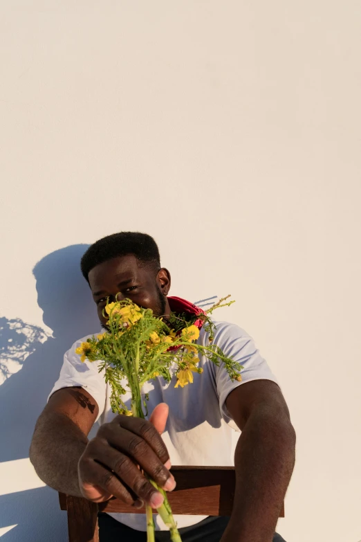 a man sitting on a chair holding a bouquet of flowers, an album cover, by Stokely Webster, pexels contest winner, man is with black skin, sun is shining, profile pic, ignant