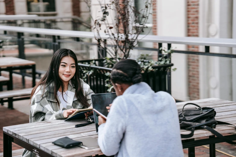 a couple of people that are sitting at a table, trending on pexels, happening, asian female, in a city square, networking, background image