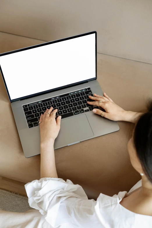 a woman sitting on a couch using a laptop computer, pexels, top-down shot, chinese, thumbnail, digital image