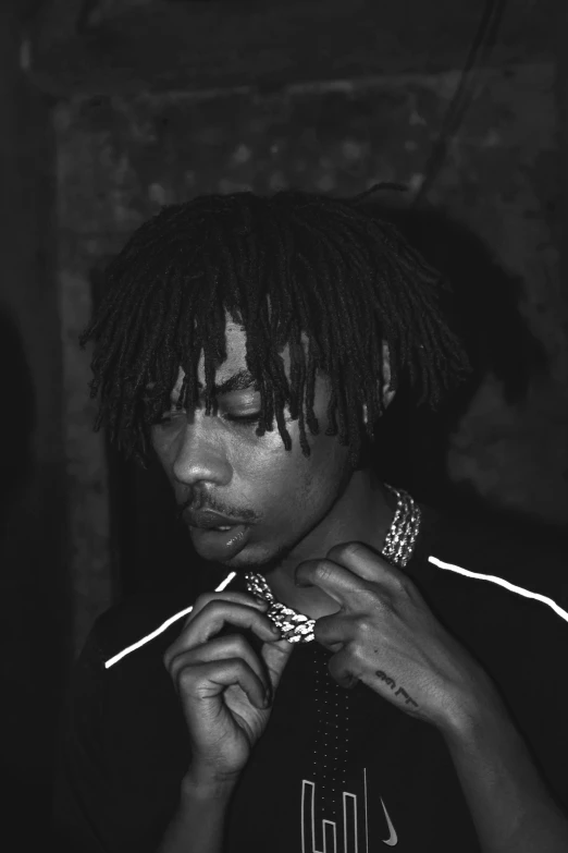 a black and white photo of a man with dreadlocks, inspired by Zhu Da, with a bob cut, playboi carti, ((chains)), candlelit