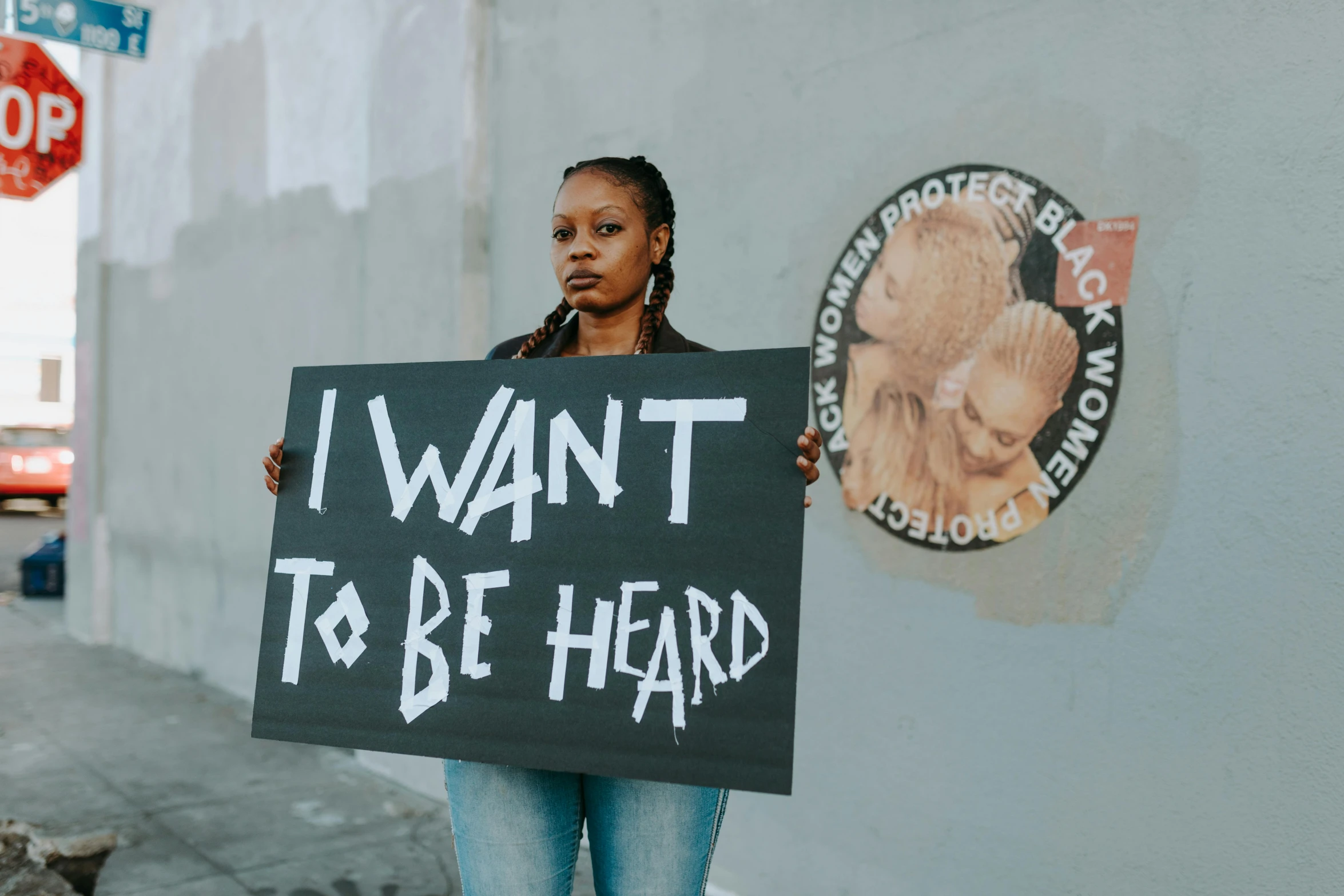 a woman holding a sign that says i want to be hard, an album cover, trending on pexels, black arts movement, ears, forced witness, womanhood, support