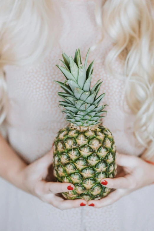 a woman holding a pineapple in her hands, by Julia Pishtar, trending on unsplash, blonde - haired princess, close - up studio photo, made of glazed, multiple stories