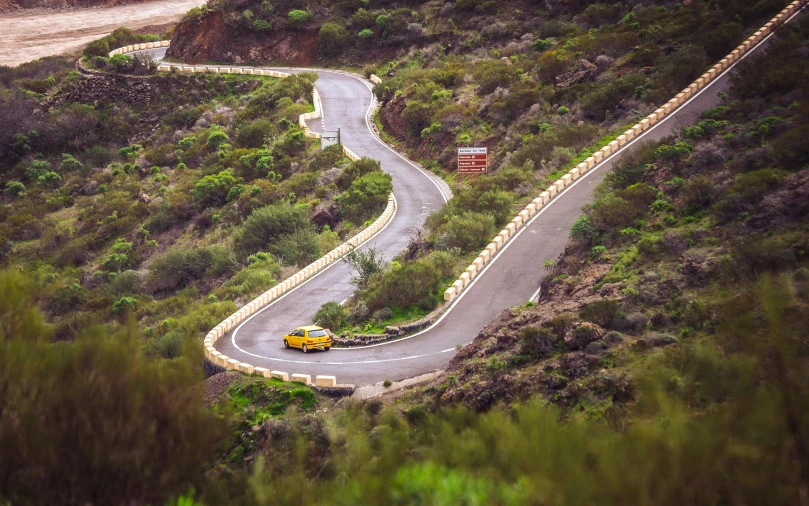 two cars driving down a winding highway on either side