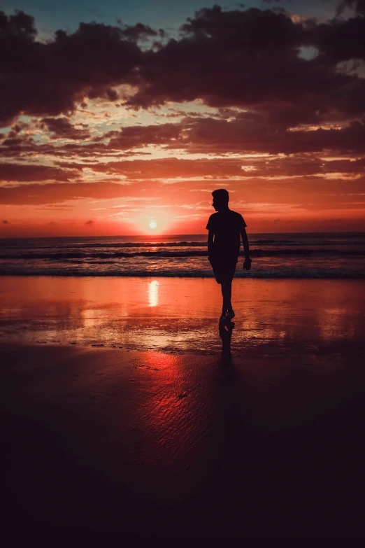 a person walking on a beach at sunset, during a sunset, profile image