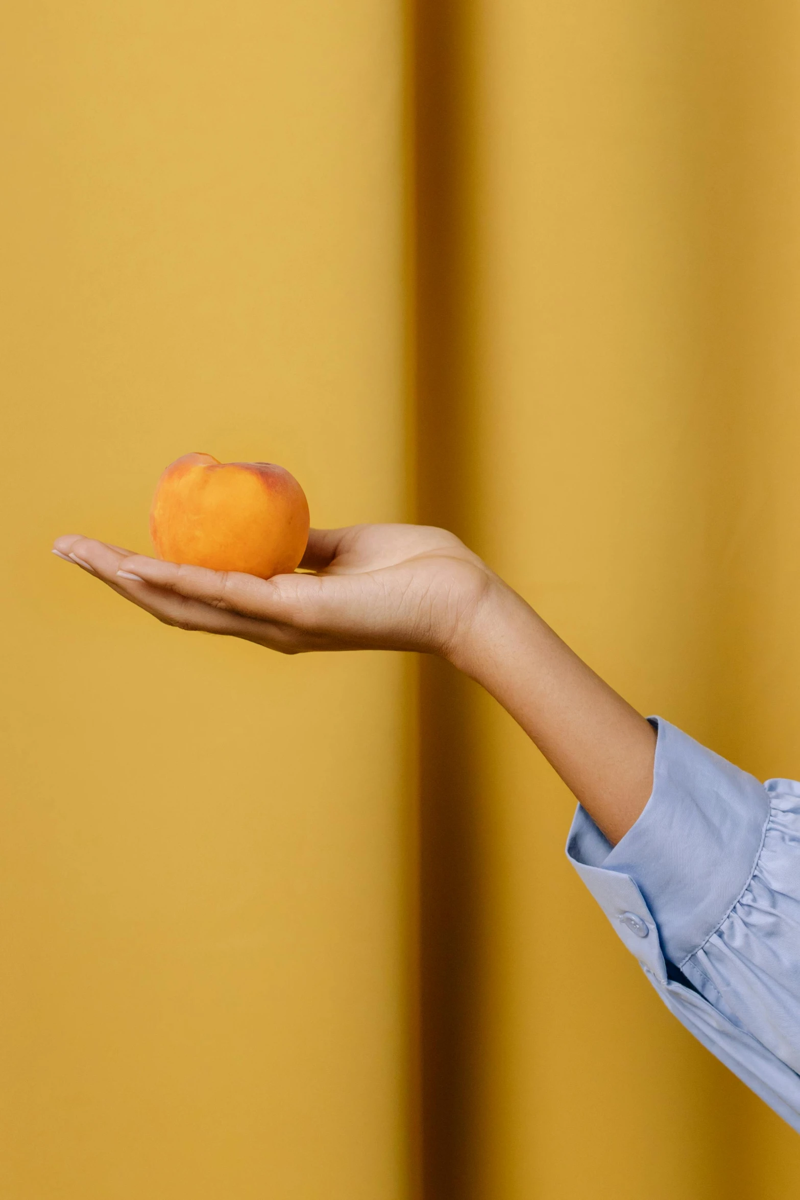 a woman holding an orange in her hand, by Gavin Hamilton, trending on unsplash, clemens ascher, zoomed in, golden apple, (light orange mist)