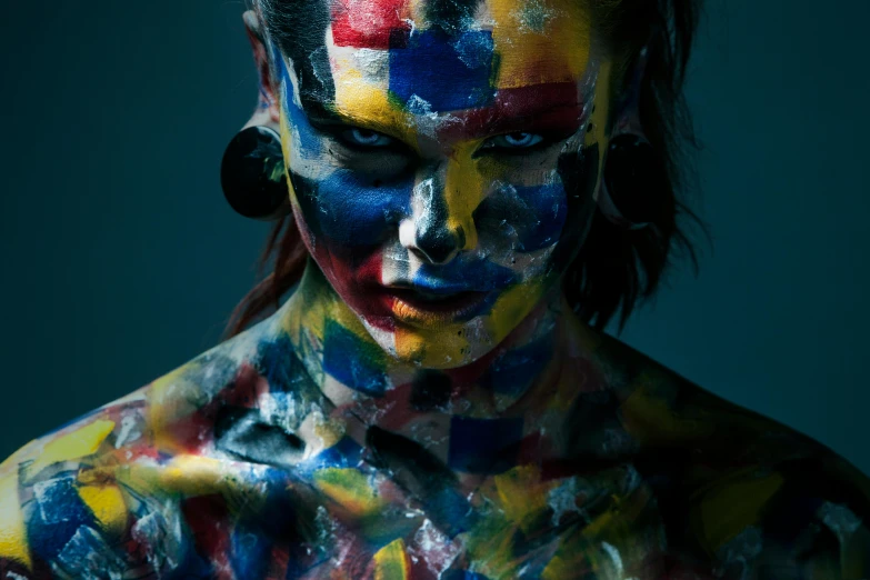 a close up of a person with paint on their body, an airbrush painting, by Adam Marczyński, pexels contest winner, art photography, multicolored faces, red yellow blue, portrait of a barbarian woman, painting on grey scale face