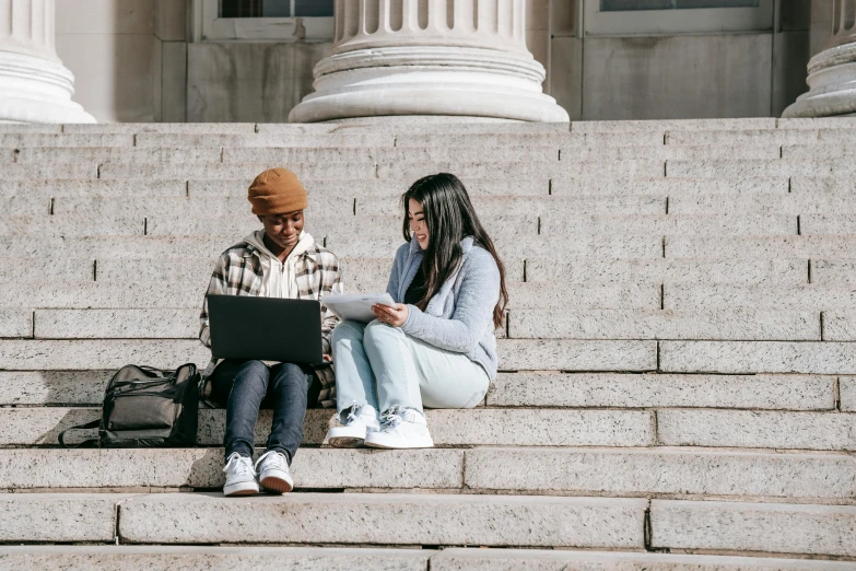 a couple of people sitting on some steps with a laptop, trending on pexels, academic art, college girls, while marble, diverse, 1 4 9 3