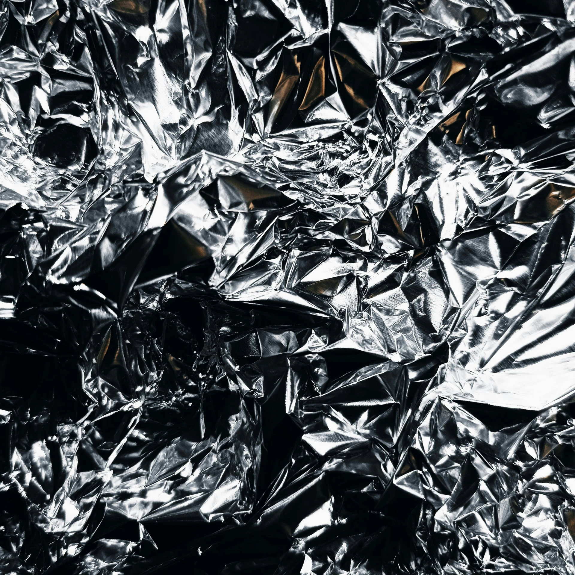 a pile of tin foil sitting on top of a table, pexels contest winner, conceptual art, high contrast 8k, metallic patterns, crystal material, black paper