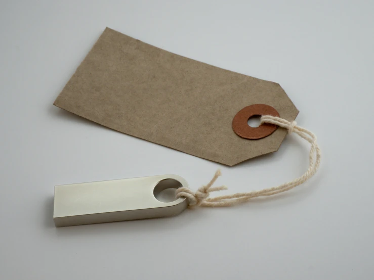 a piece of paper with a tag attached to it, aluminium, handcrafted, usb ports, esher