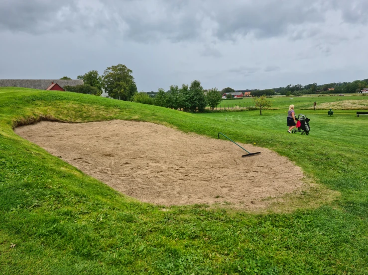 a man riding a lawn mower on top of a lush green field, a picture, by Tom Wänerstrand, land art, sand piled in corners, golf course, thumbnail, sportspalast amphitheatre