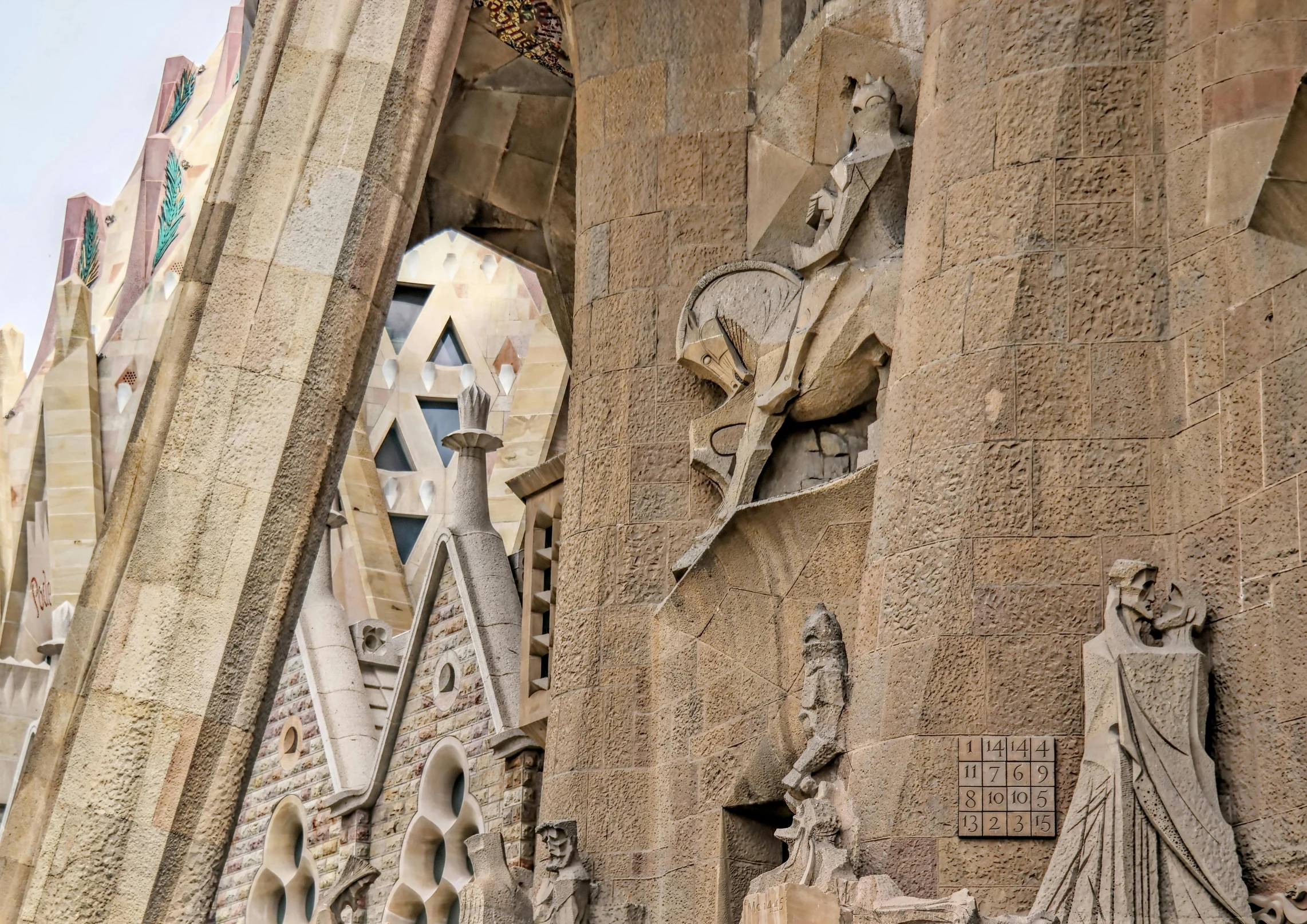 a group of statues on the side of a building, a mosaic, by Gaudi, pexels contest winner, collapsed brutalist architecture, pointed arches, intricate 8 k detail, asymmetrical spires