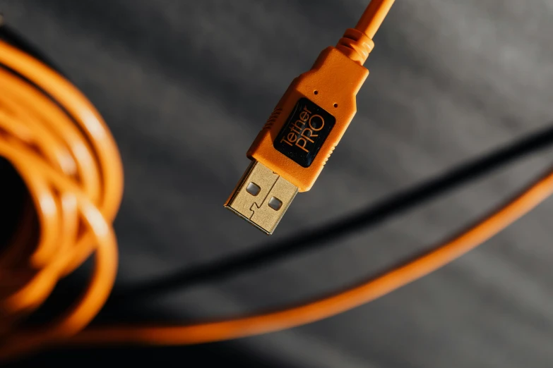 a close up of a usb cable connected to a charger, by Paul Bird, pexels, process art, orange halo, high resolution product photo, the pyro, product view