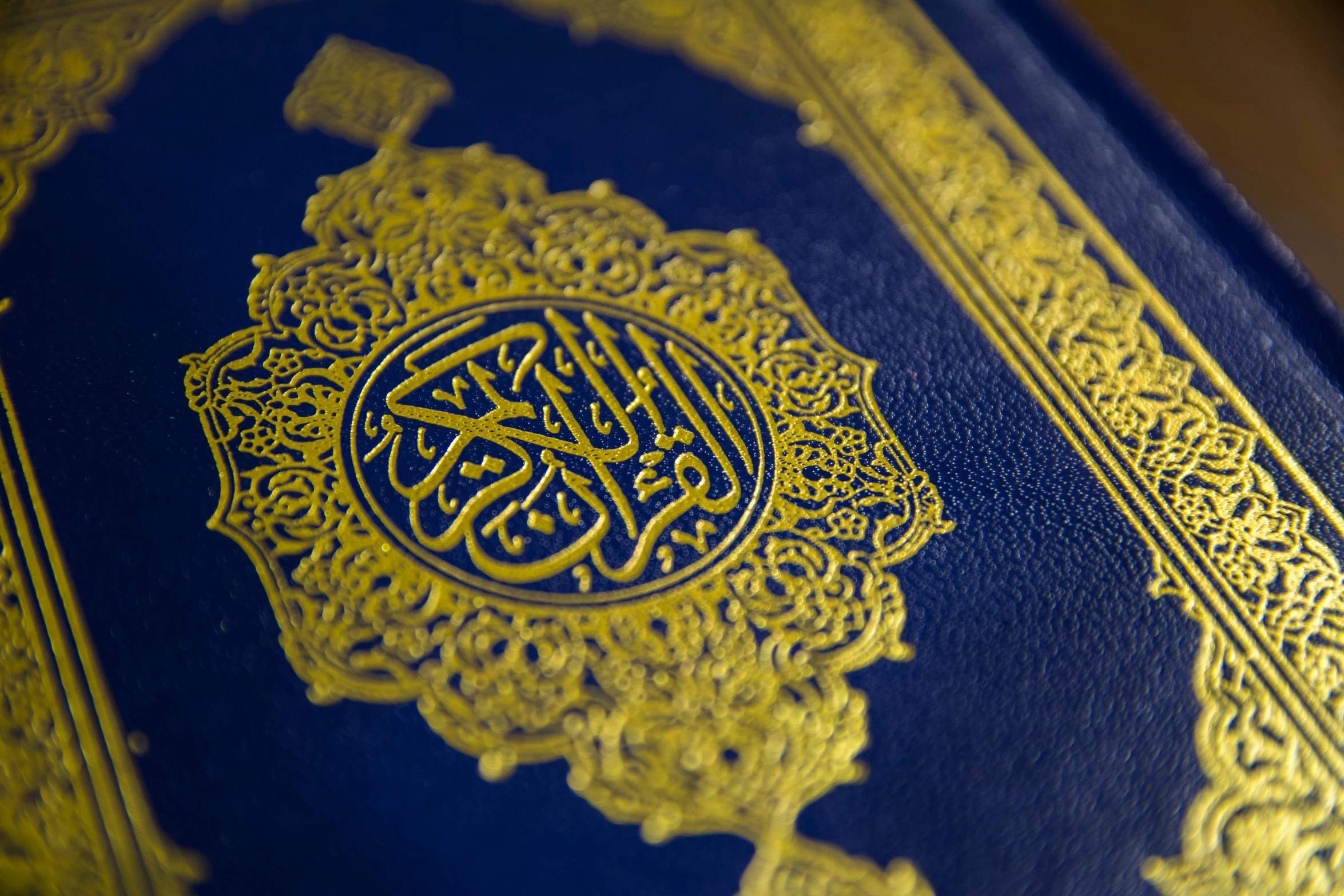 a blue book sitting on top of a wooden table, hurufiyya, highly detailed gold filigree, praise the omnissaiah, intricate embroidery, finer details