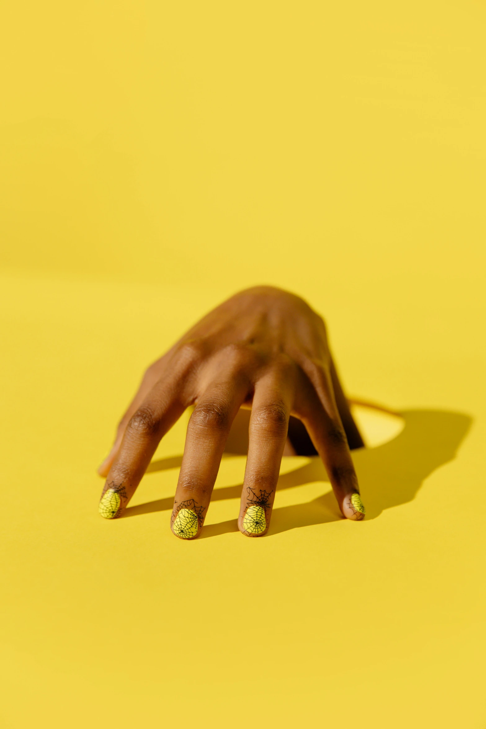 a woman's hand with green nails on a yellow background, inspired by Bert Stern, trending on pexels, hyperrealism, kehinde wiley, patterned, shot with sony alpha 1 camera, sitting on man's fingertip