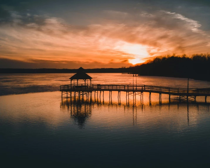 a pier sitting on top of a body of water, by Carey Morris, pexels contest winner, sunset warm spring, drone footage, lake house, 2 0 2 2 photo