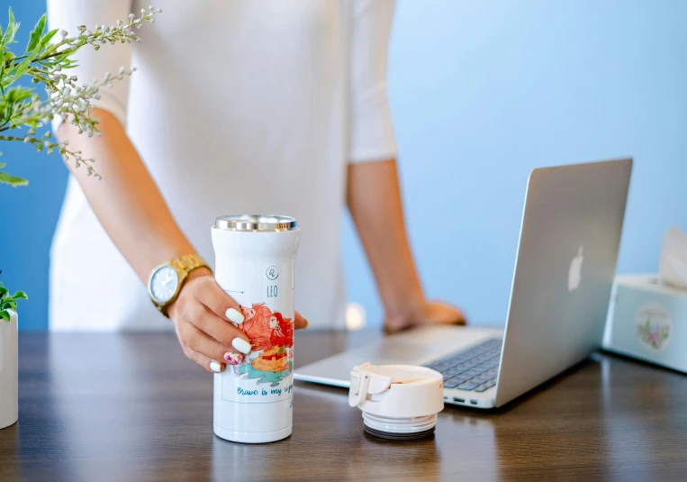 a woman standing in front of a laptop and a blender, trending on unsplash, paper cup, detailed product shot, holding a tin can, kano tan'yu