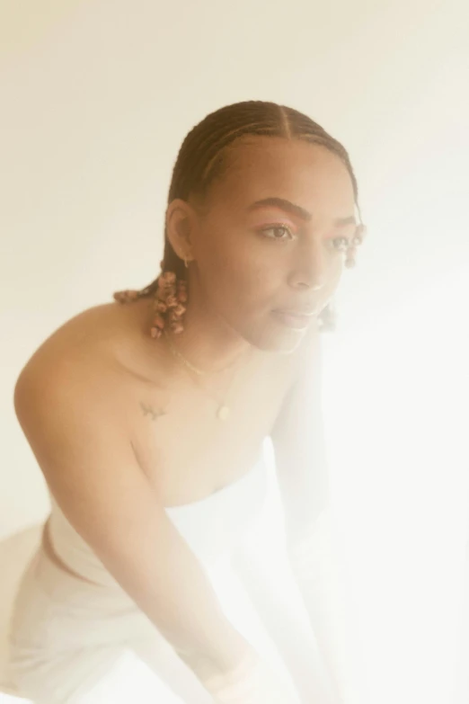 a woman sitting on top of a bed next to a window, an album cover, by Jessie Alexandra Dick, trending on pexels, cornrows, sun flare, delicate androgynous prince, pictured from the shoulders up