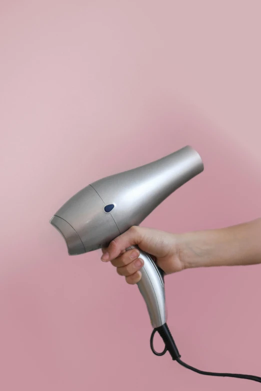 a person holding a hair dryer in their hand, by Carey Morris, pexels, photorealism, hammershøi, silver color, with accurate features, speculum