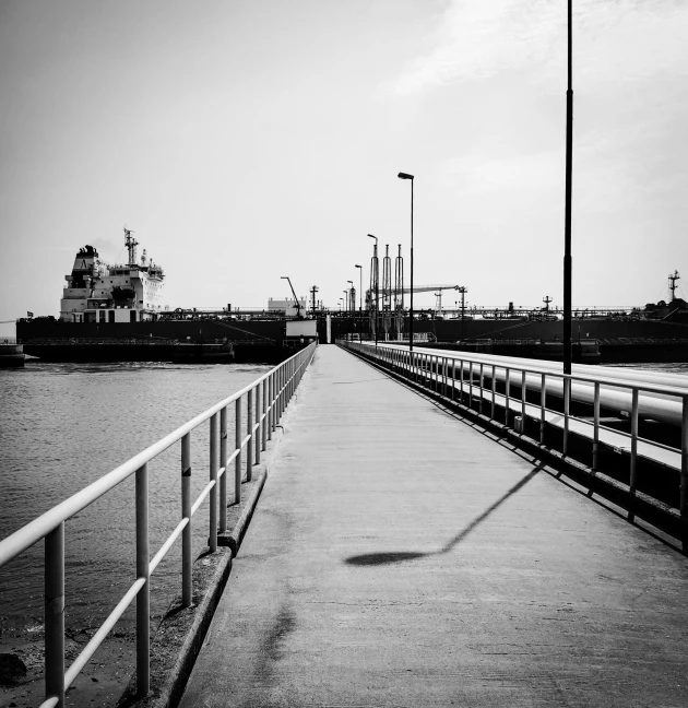 a black and white photo of a pier, by Jacob Toorenvliet, in a sci-fi shipping port, photographic print, # myportfolio, walking away