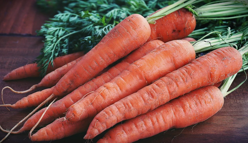 a bunch of carrots sitting on top of a wooden table