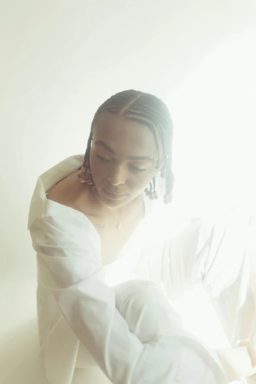 a woman sitting on top of a bed next to a window, an album cover, by Lily Delissa Joseph, unsplash, visual art, wearing a white button up shirt, cornrows, soft backlighting, 3 / 4 pose