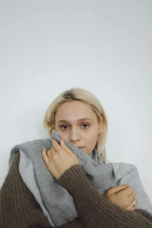 a woman wrapped up in a blanket, an album cover, inspired by Louisa Matthíasdóttir, grey turtleneck coat, clear background, asher duran, loosely cropped