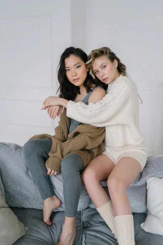 a couple of women sitting on top of a couch, inspired by Wang Duo, trending on pexels, renaissance, wearing casual sweater, bare thighs, jen yoon, posing in bed