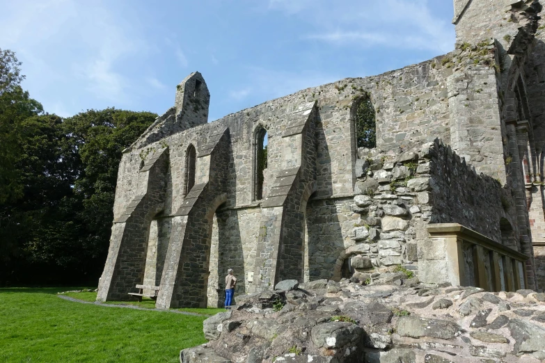 a man standing in front of a stone building, inside a ruined abbey, scylla, church cathedral, spacious