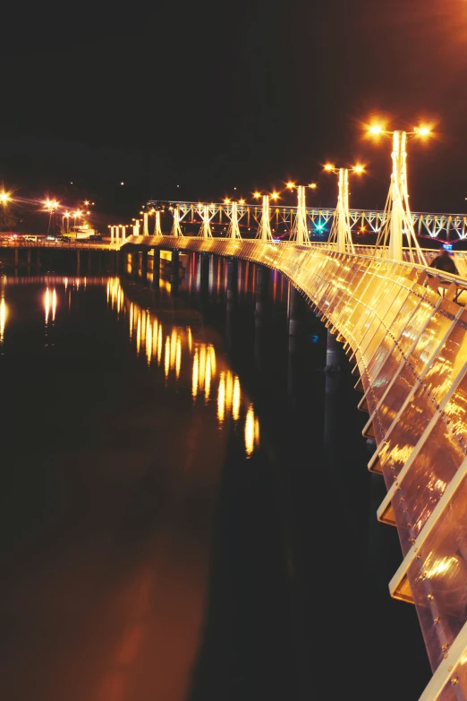 a bridge over a body of water at night, happening, decorations, guwahati, zoomed in, brightly lit!
