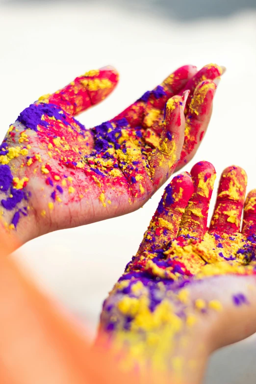 a close up of a person's hands covered in paint, by Julia Pishtar, pexels, some red and purple and yellow, hindu aesthetic, covered in sprinkles and crumbs, large patches of plain colours