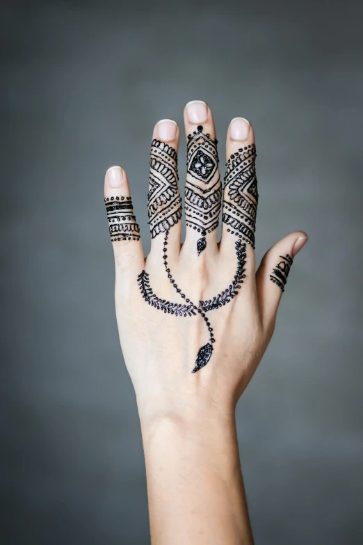 a woman's hand with henna tattoos on it, a tattoo, inspired by Amir Zand, sci - fi jewellery, medium close shot, instagram post, tall