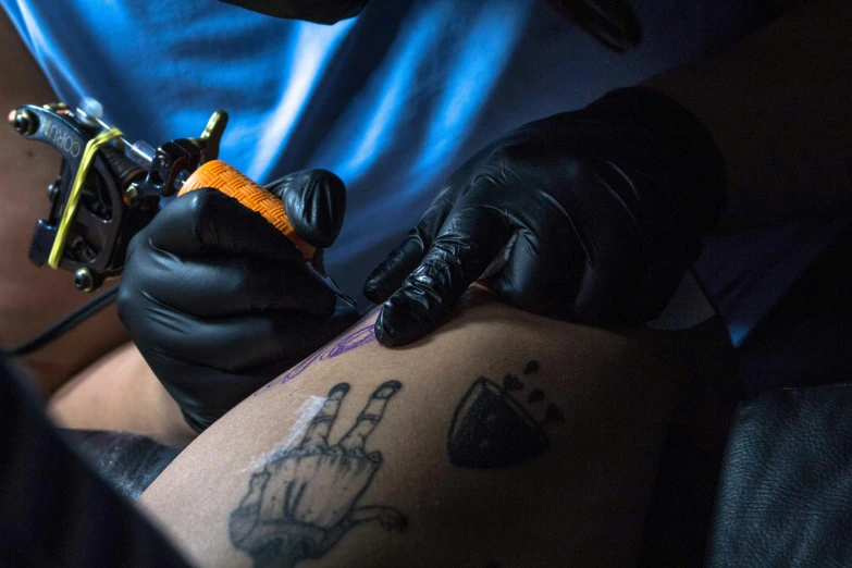 a man getting a tattoo on his leg, a tattoo, by Adam Marczyński, neon ink, thumbnail, mid shot photo, ap art