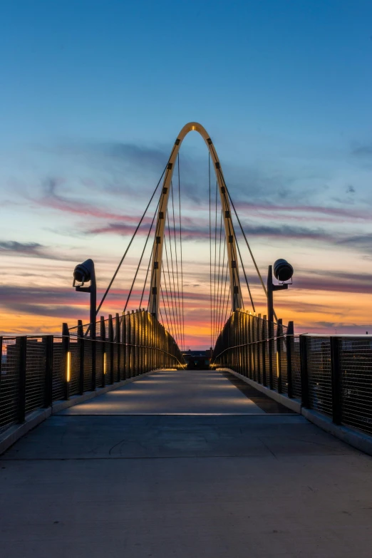 a bridge over a body of water at sunset, standing on a bridge, walkway, in the evening