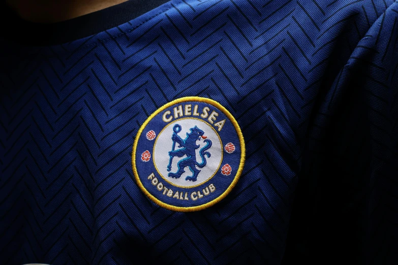 a close up of a soccer jersey with a badge on it, blue - print, dezeen, extra crisp image, cheesy