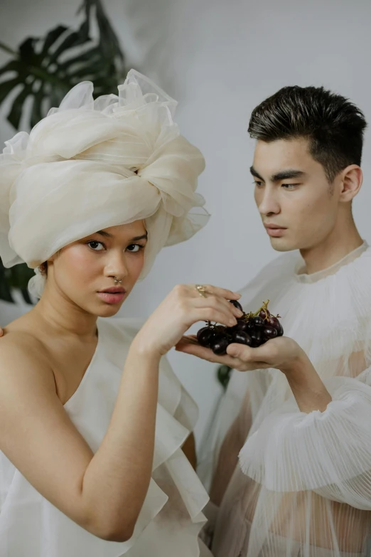 a man and a woman standing next to each other, a portrait, unsplash, conceptual art, organic headpiece, pastry, mai anh tran, at a fashion shoot