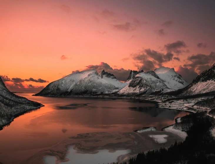 a large body of water surrounded by snow covered mountains, by Sebastian Spreng, pexels contest winner, romanticism, orange / pink sky, nordic, grey, conde nast traveler photo