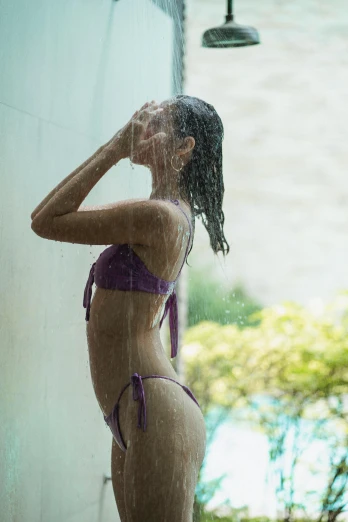 a woman in a purple bikini standing under a shower, bali, profile image, concern, showers