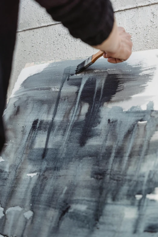 a person using a brush to paint a painting, inspired by Hans Hartung, modern european ink painting, grey, charcoal