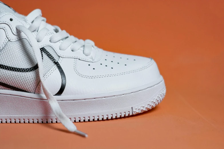a pair of white nike air force sneakers, by Gavin Hamilton, trending on pexels, photorealism, hoog detail, orange and white, white and black clothing, tonal topstitching