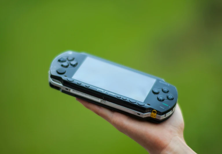 a close up of a person holding a cell phone, psp, the console is tall and imposing, gamedev, taken in the late 2010s