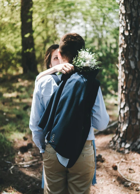 a man and woman standing next to each other in the woods, unsplash, romanticism, carrying flowers, backpack, profile image, navy