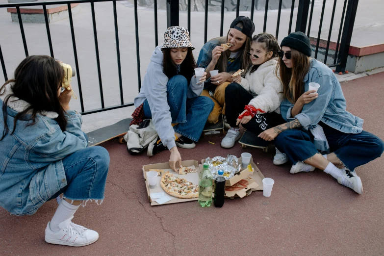 a group of girls sitting on the ground eating pizza, by Elsa Bleda, trending on pexels, realism, skateboarder style, with fries, denim, 40 years old women