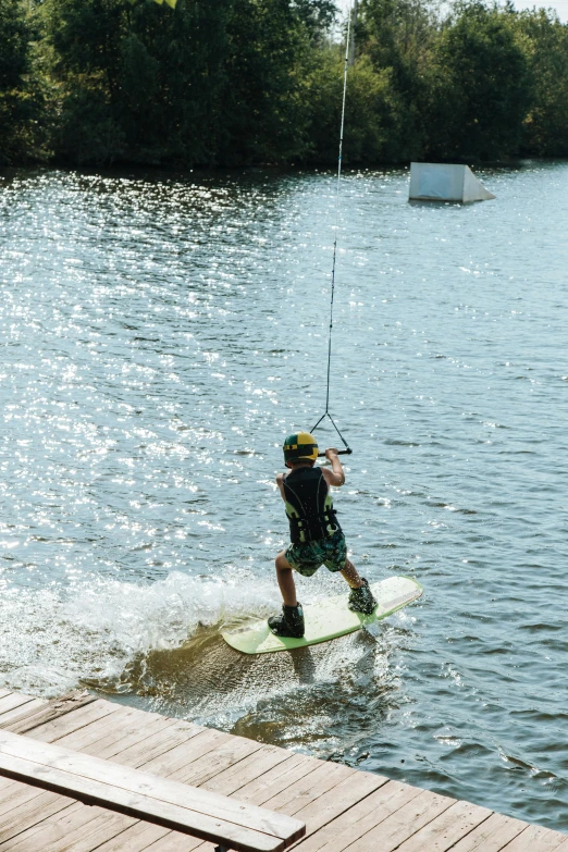 a man riding a wake board on top of a lake, brockholes, water park, at the waterside, charts