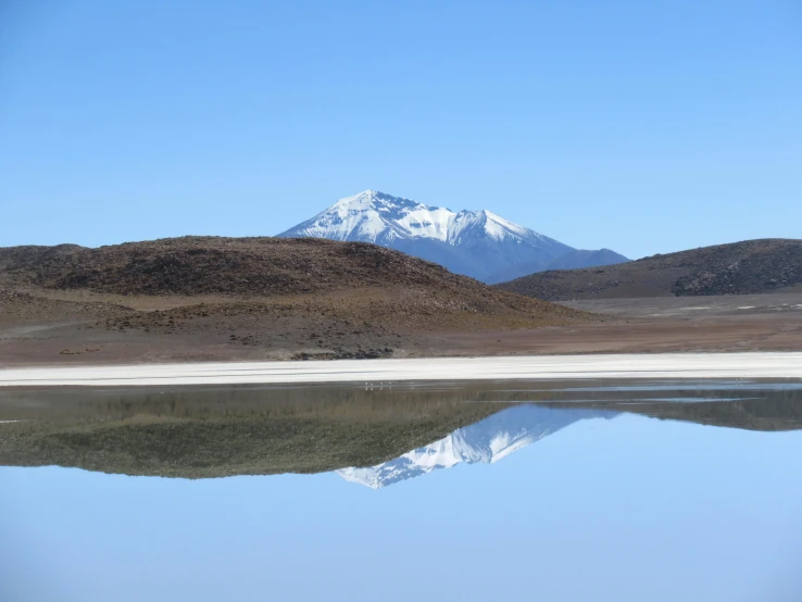 a body of water with a mountain in the background, salt dunes, avatar image