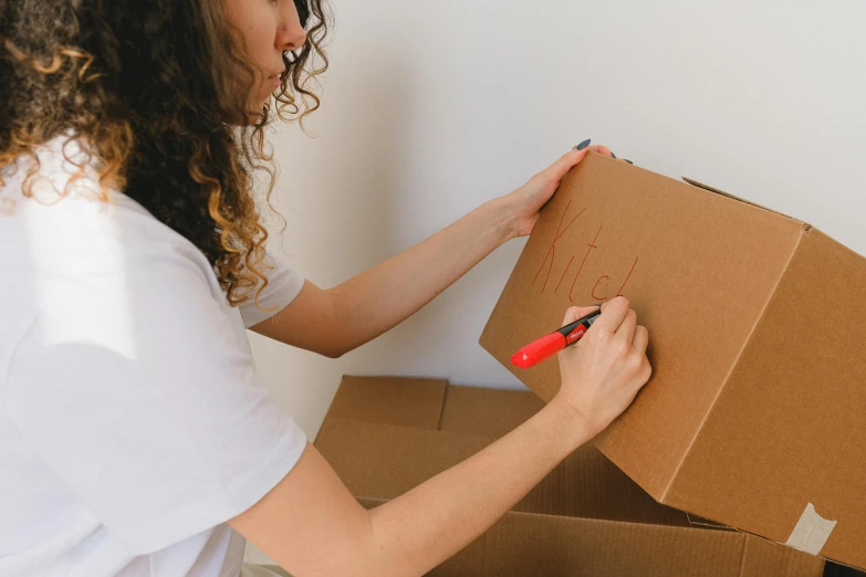 a woman is putting a piece of cardboard in a box, by Carey Morris, pexels contest winner, graffiti, whiteboards, alana fletcher, leaked image, thumbnail