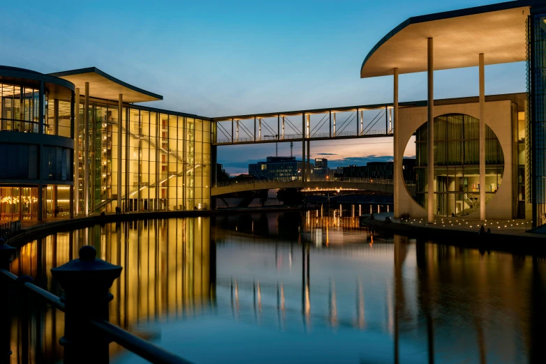 a bridge over a body of water next to a building, by Sebastian Spreng, pexels contest winner, bauhaus, palast der republik in berlin, in the evening, slide show, neo classical architecture