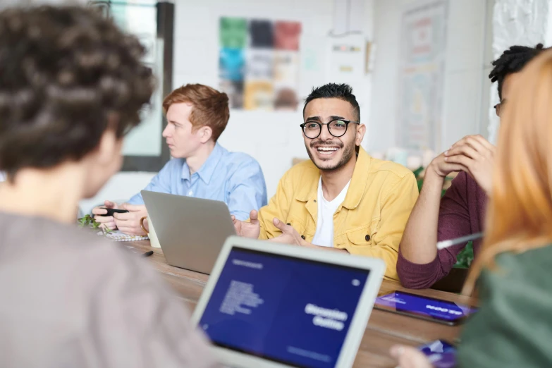 a group of people sitting around a table with laptops, trending on pexels, academic art, future coder man looking on, lachlan bailey, proud looking, thumbnail